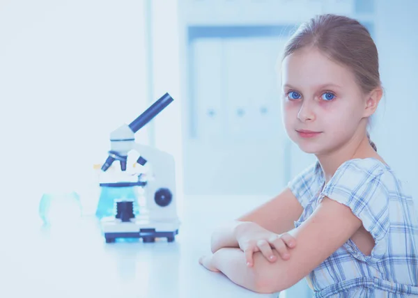 Schoolgirl looking through microscope in science class. — Stock Photo, Image