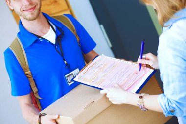 Mavi üniformalı gülümseyen kurye servis konseptine paket kutusu teslim eden teslimatçı. Mavi üniformalı gülümseyen teslimatçı.