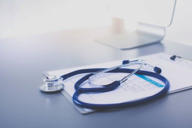 Tıbbi ekipman: Beyaz arka planda mavi steteskop ve tablet. Tıbbi ekipman