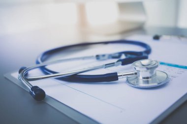 Tıbbi ekipman: Beyaz arka planda mavi steteskop ve tablet. Tıbbi ekipman