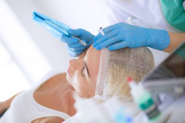 Kaşlar için kalıcı makyaj. Güzellik salonunda kalın kaşlı güzel bir kadın..