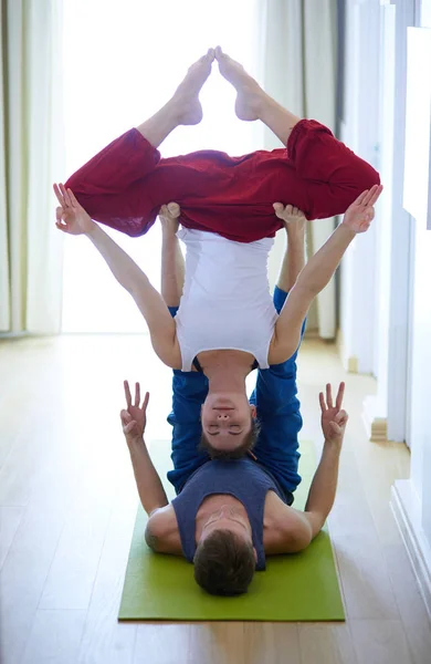 Молодая пара в положении йоги на белом фоне — стоковое фото