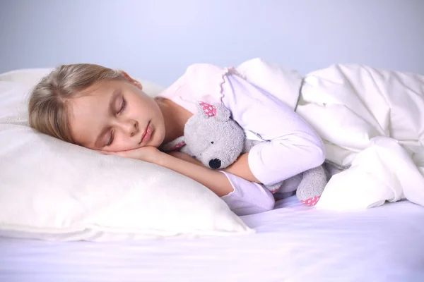 어린이 장난감 테 디 베어와 함께 침대에서 자는 어린 소녀. — 스톡 사진