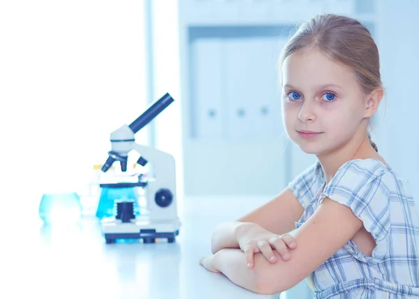 Schülerin schaut im naturwissenschaftlichen Unterricht durchs Mikroskop. — Stockfoto
