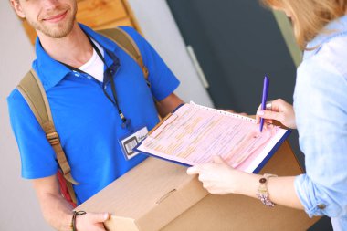 Mavi üniformalı gülümseyen kurye servis konseptine paket kutusu teslim eden teslimatçı. Mavi üniformalı gülümseyen teslimatçı.