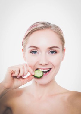 Beyaz zemin üzerine salatalık dilimleri ile genç güzel kadın