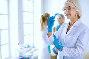 Güzel kadın elinde şırıngayla doktorun yanında duruyor.