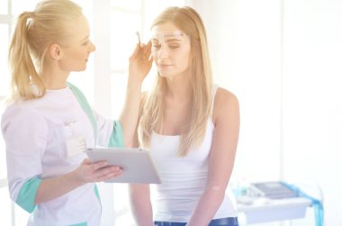 Kaşlar için kalıcı makyaj. Güzellik salonunda kalın kaşlı güzel bir kadın..