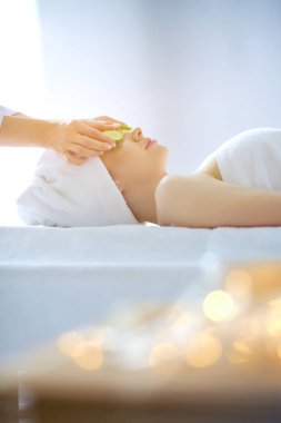 Masaj masasında uzanmış gözleri kapalı rahatlayan genç bir kadın. - Kadın. Spa salonu