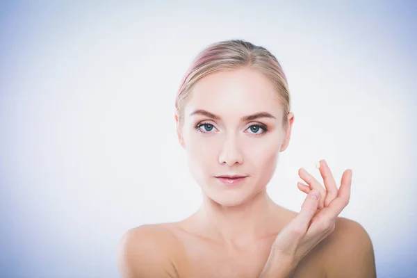 Portrait of happy smiling beautiful young woman touching skin or applying cream, isolated over white background — Stock Photo, Image