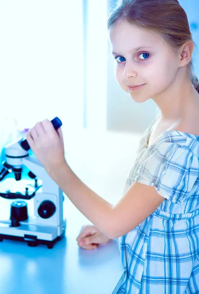 Schoolmeisje op zoek via Microscoop in de wetenschap klasse — Stockfoto