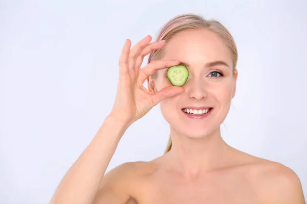 Joven hermosa mujer con rodajas de pepino sobre fondo blanco — Foto de Stock