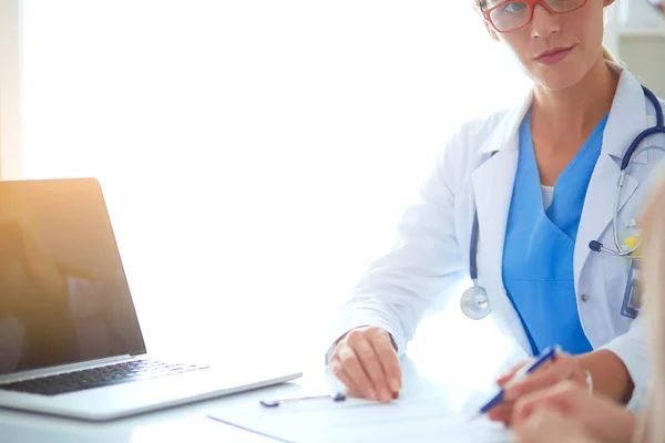 Dokter en geduldig stel bespreken iets, zitten op het bureau. — Stockfoto