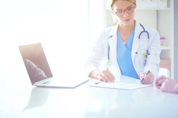 Dokter en geduldig stel bespreken iets, zitten op het bureau. — Stockfoto