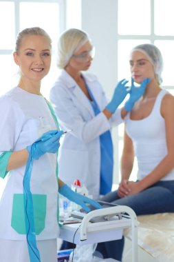 Güzel kadın elinde şırıngayla doktorun yanında duruyor..