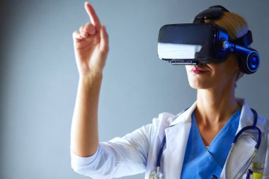 Sanal gerçeklik gözlüğü takan kadın doktor beyaz arka planda izole edilmiş..