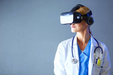 Sanal gerçeklik gözlüğü takan kadın doktor beyaz arka planda izole edilmiş..