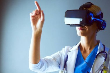 Sanal gerçeklik gözlüğü takan kadın doktor beyaz arka planda izole edilmiş..