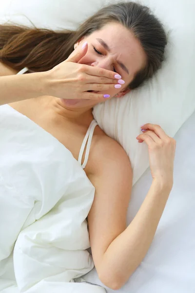 Hübsche Frau legt sich zu Hause auf ihr Bett — Stockfoto