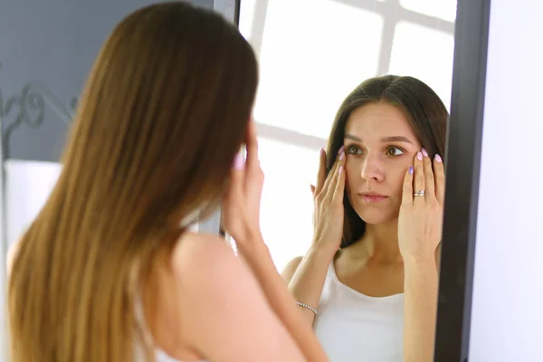 Jonge vrouw zichzelf reflectie in spiegel thuis kijken — Stockfoto