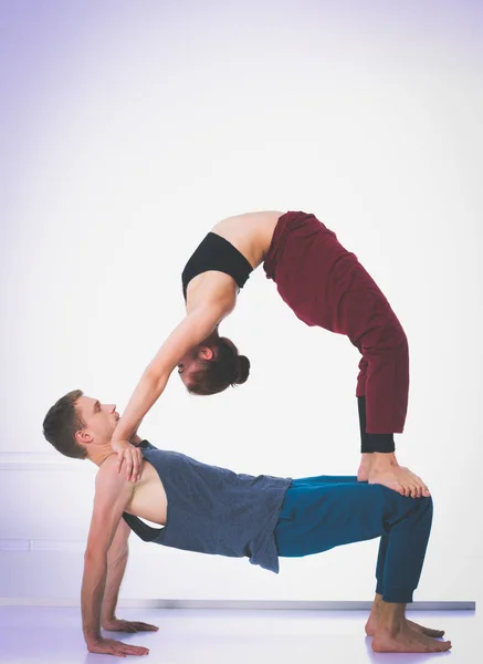 Pareja atlética joven practicando acroyoga. Balanceo en pareja . — Foto de Stock