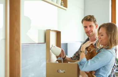 Genç bir çift yeni evde büyük karton kutu taşıyan. Ev taşıma. Genç Çift