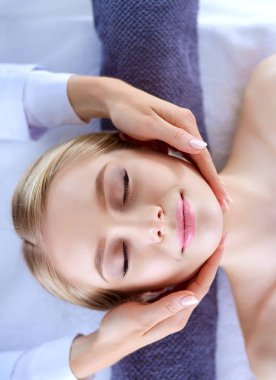 Masaj masasında uzanmış gözleri kapalı rahatlayan genç bir kadın. - Kadın. Spa salonu