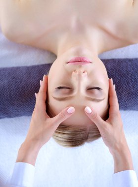 Masaj masasında uzanmış gözleri kapalı rahatlayan genç bir kadın. - Kadın. Spa salonu