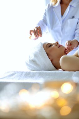 Masaj masasında uzanmış gözleri kapalı rahatlayan genç bir kadın. - Kadın. Spa salonu