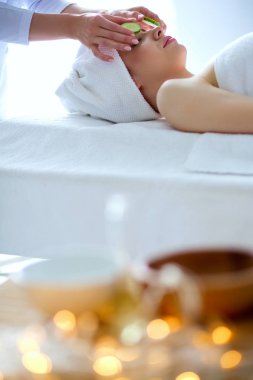 Masaj masasında uzanmış gözleri kapalı rahatlayan genç bir kadın. - Kadın. Spa salonu