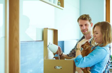 Genç bir çift yeni evde büyük karton kutu taşıyan. Ev taşıma. Genç Çift