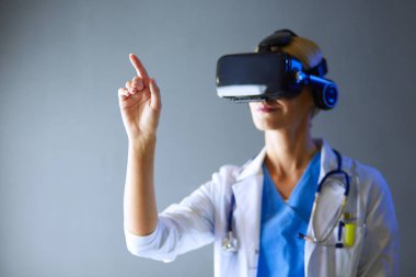 Sanal gerçeklik gözlüğü takan kadın doktor beyaz arka planda izole edilmiş..