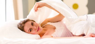 Güzel bir kadın yatağında uzanıyor..