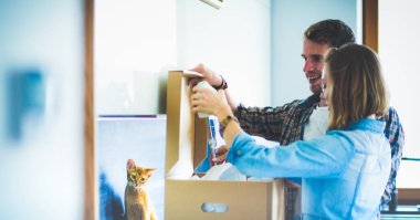 Genç bir çift yeni evde büyük karton kutu taşıyan. Ev taşıma. Genç Çift