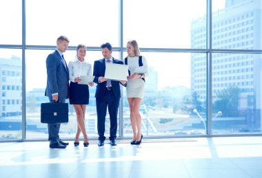 Grup iş adamları toplantı sırasında dizüstü bilgisayar ile sunum yapıyor. Grup iş adamları