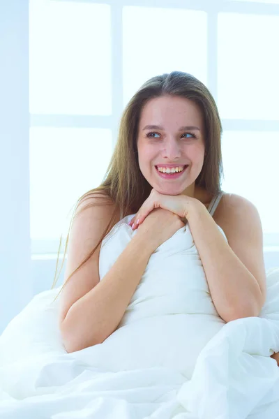 Young caucasian woman covering her head and ears with pillows — Stock Photo, Image