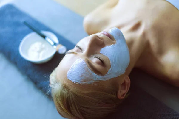 Mascarilla facial. Hermosa joven en el spa, mujer cosmética aplicando mascarilla facial . —  Fotos de Stock