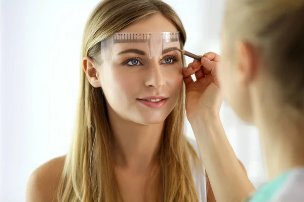 Maquiagem permanente para sobrancelhas. Close-up de mulher bonita com sobrancelhas grossas no salão de beleza. — Fotografia de Stock