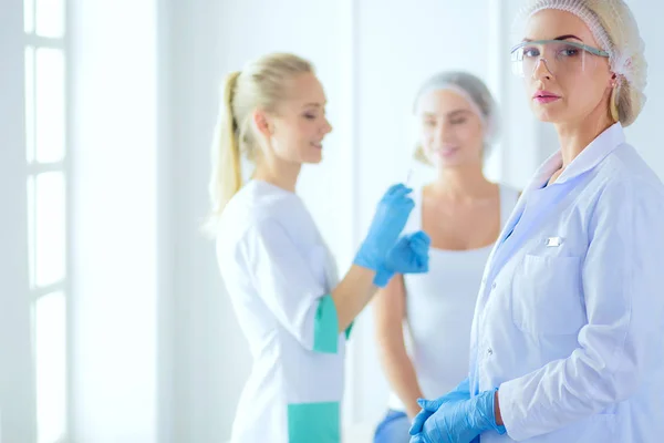 Beautiful woman face near doctor with syringe. — Stock Photo, Image