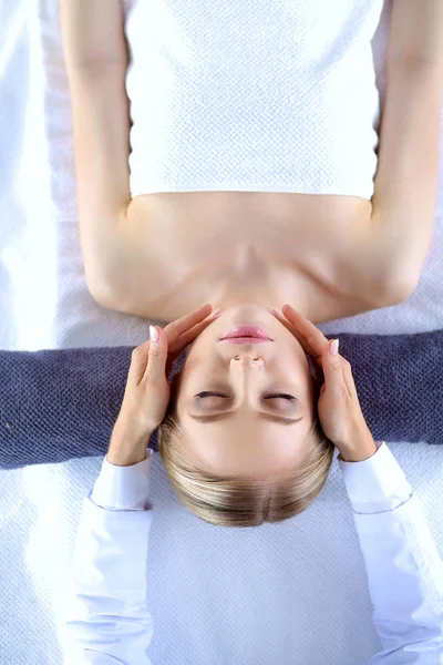 Jonge vrouw liggend op een massagetafel, ontspannend met gesloten ogen. Vrouw. Kuuroord — Stockfoto