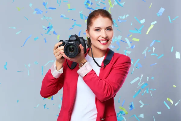 Schöne, glückliche Frau mit Kamera bei einer Feier mit Konfetti. Geburtstag oder Silvester feiern Konzept — Stockfoto