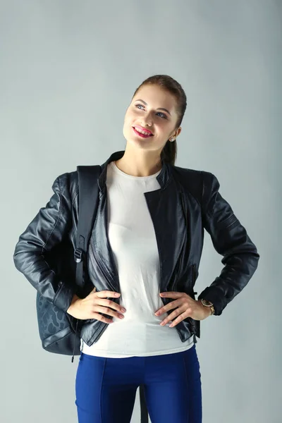 Portrait of beautiful young brunette woman in stylish black jacket on gray. — Stock Photo, Image