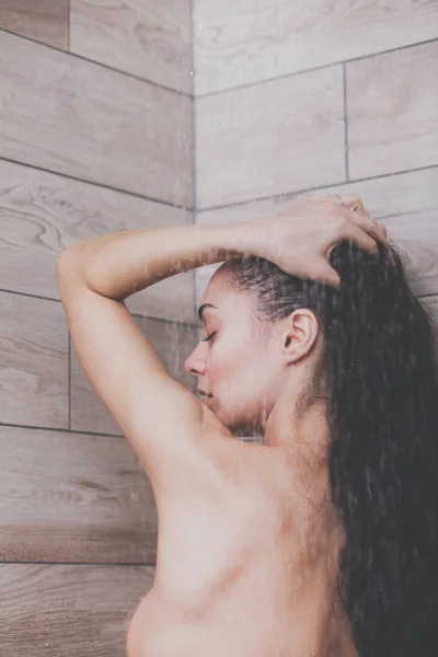 Jeune femme belle sous la douche dans la salle de bain . — Photo