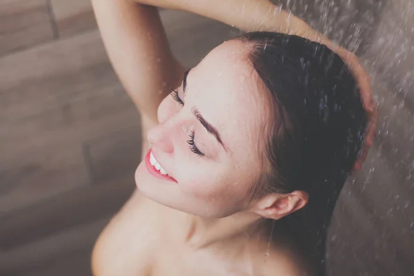 Junge schöne Frau unter der Dusche im Badezimmer. — Stockfoto