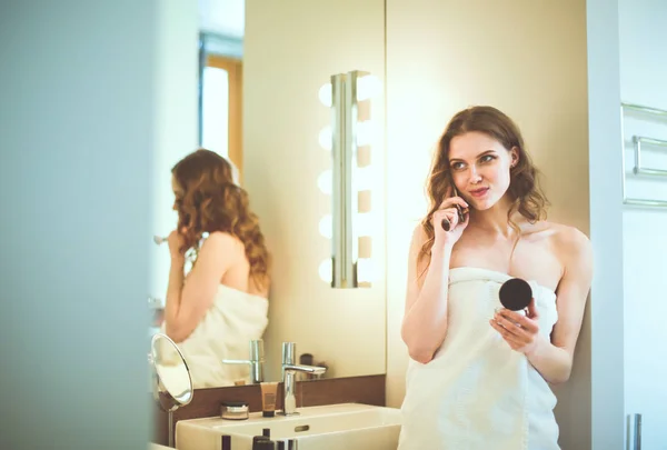 Jovem mulher de pé no banheiro com telefone . — Fotografia de Stock