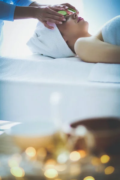 Νεαρή γυναίκα ξαπλωμένη σε ένα τραπέζι μασάζ, χαλαρώνοντας με τα μάτια κλειστά. Γυναίκα. Σαλόνι σπα — Φωτογραφία Αρχείου