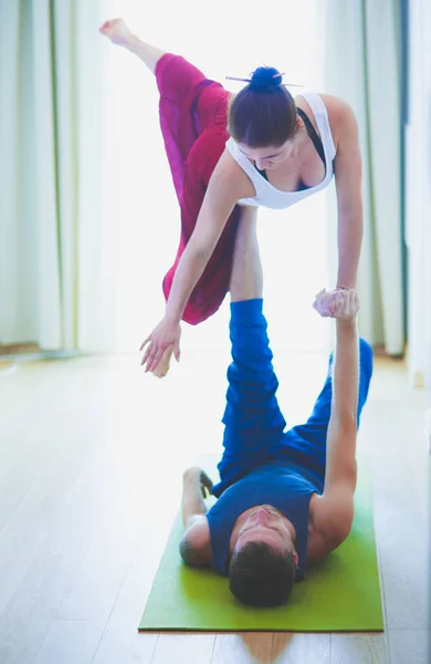 Young healthy couple in yoga position on white background