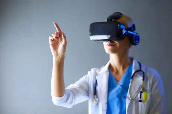 Médecin féminin portant des lunettes de réalité virtuelle isolées sur fond blanc. — Photo