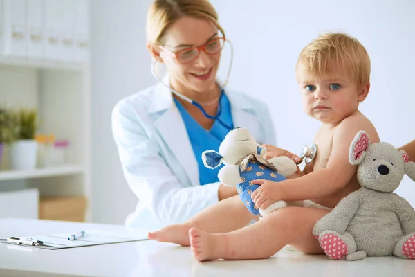 Ženský doktor poslouchá dítě se stetoskopem na klinice — Stock fotografie