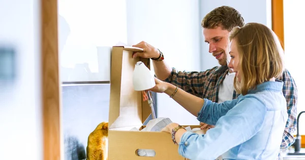 Young couple carrying big cardboard box at new home.Moving house. Young couple — Stock Photo, Image